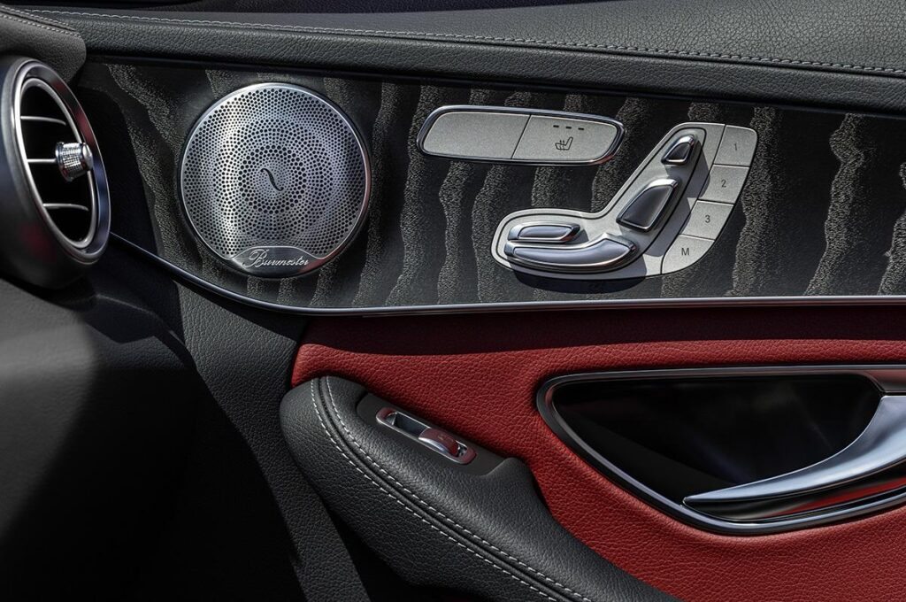 Close-up of Mercedes C-Class door panel with Burmester speakers and heated seat controls